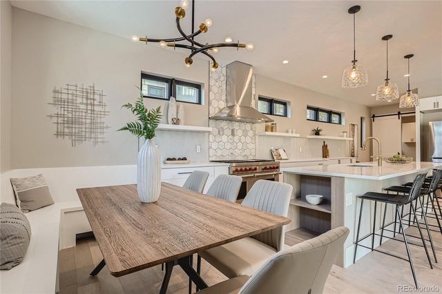 a dining room with a table chairs and a kitchen view