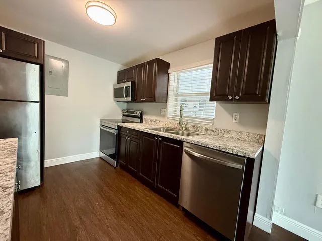 a kitchen with stainless steel appliances granite countertop a stove a sink and a refrigerator