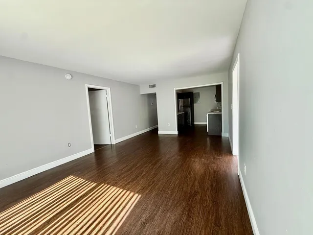 an empty room with wooden floor and closet