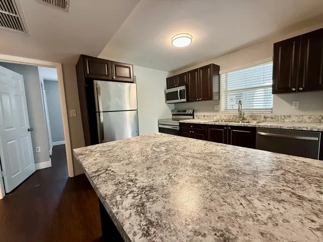 a kitchen with stainless steel appliances a refrigerator and a sink