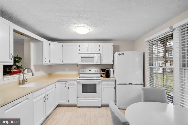 a kitchen with a white cabinets and white appliances