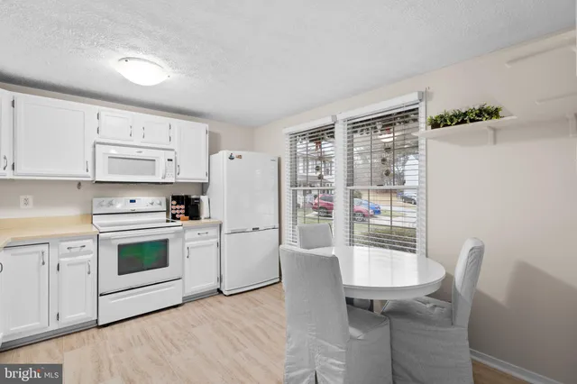a kitchen with a table chairs and a refrigerator