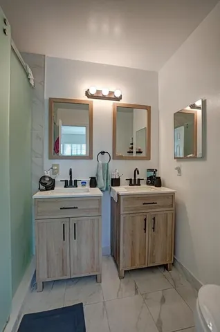 a bathroom with a sink mirror vanity and toilet