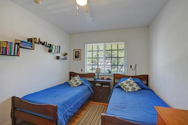 a bedroom with a bed dresser and window