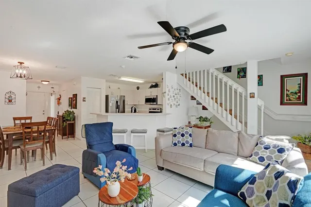 a dining room with furniture potted plants and wooden floor