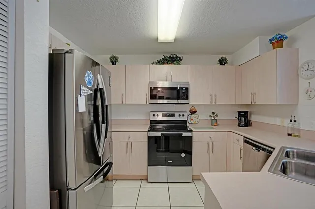 a kitchen with cabinets stainless steel appliances and a counter space