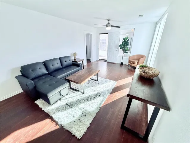 a living room with furniture and wooden floor