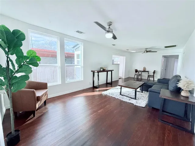 a living room with furniture and a wooden floor