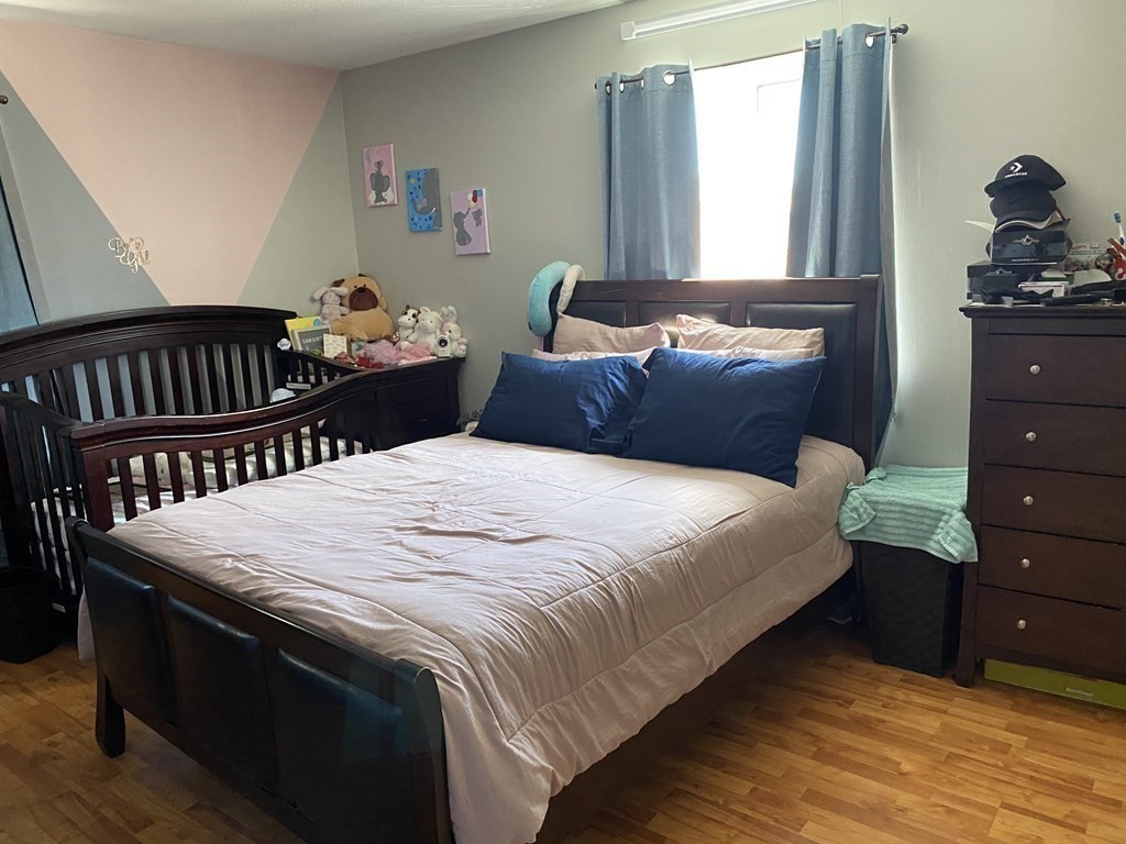 79 Nicholas Road, Unit J Framingham, MA 01701 - Photo 13 of 29 a bedroom with a bed and wooden floor