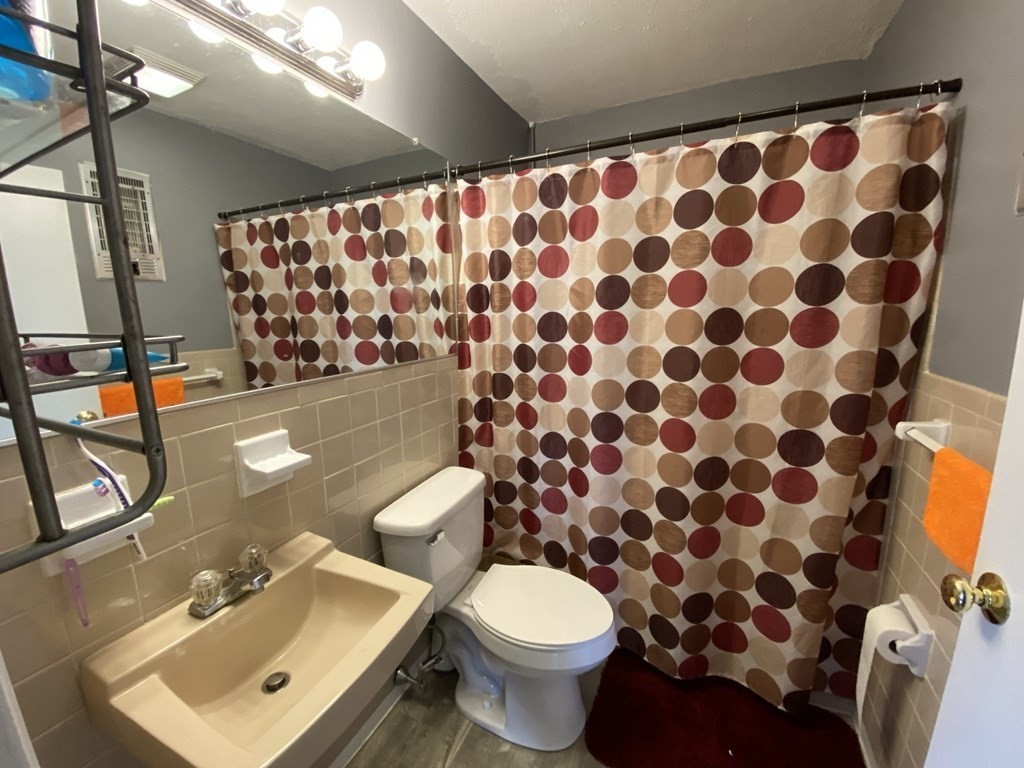 79 Nicholas Road, Unit J Framingham, MA 01701 - Photo 21 of 29 a bathroom with a toilet and a sink a mirror