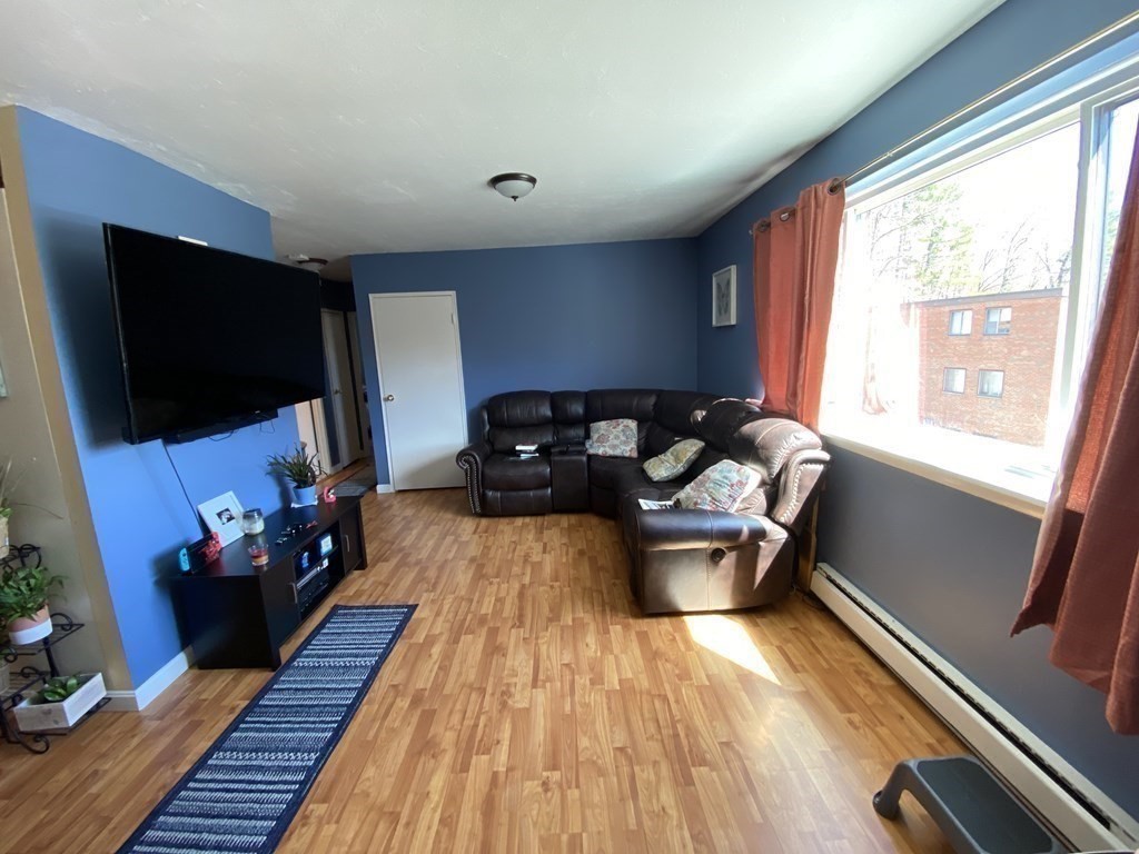 79 Nicholas Road, Unit J Framingham, MA 01701 - Photo 8 of 29 a living room with furniture and a flat screen tv