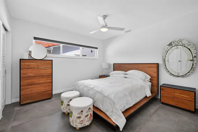 a bedroom with a bed and closet with mirror