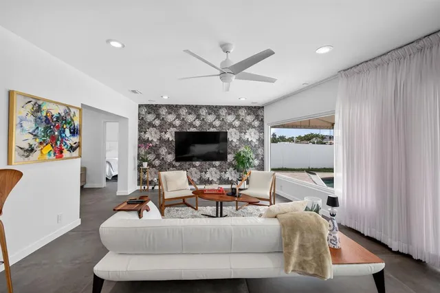 a living room with furniture and a floor to ceiling window