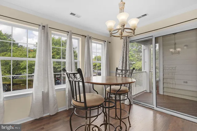 a view of a dining room with furniture wooden floor and chandelier