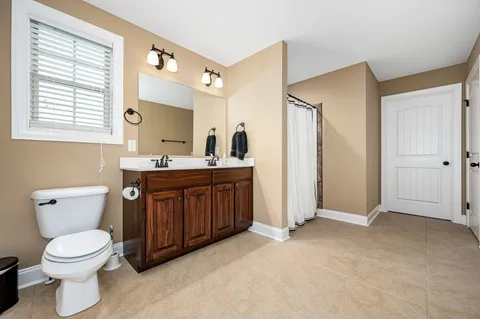 a bathroom with a toilet sink and mirror