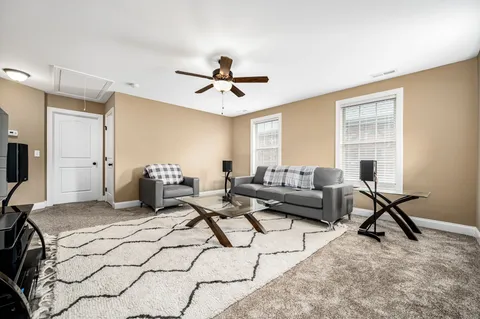 a living room with furniture a flat screen tv and a window