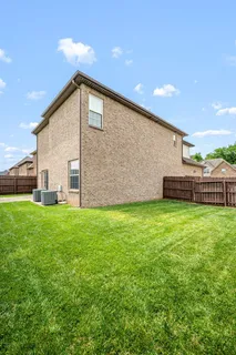 a view of a backyard with plants and wooden fence
