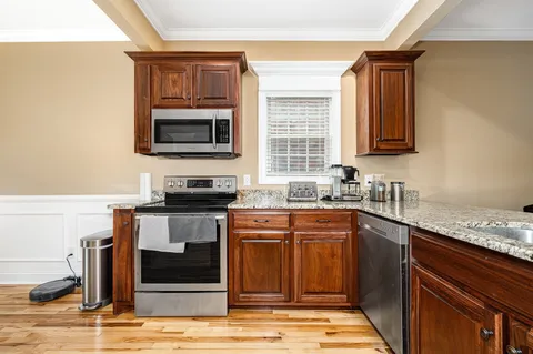 a kitchen with stainless steel appliances granite countertop a stove microwave and sink