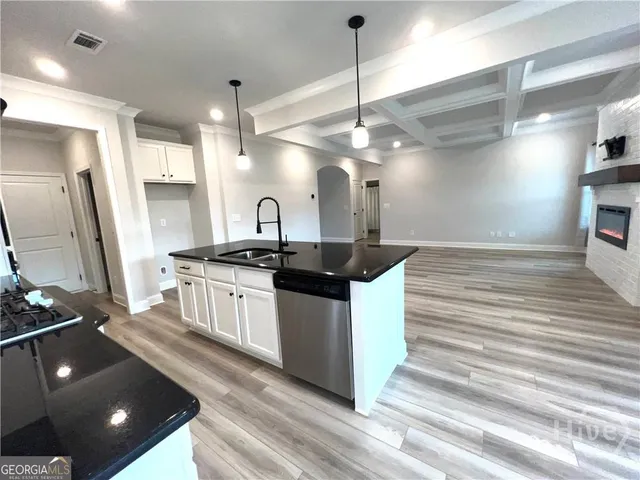 a kitchen with stainless steel appliances granite countertop a sink a counter space and cabinets