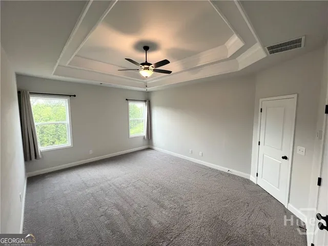 an empty room with ceiling fan and window
