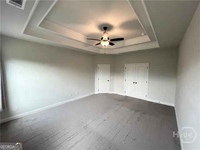 an empty room with ceiling fan and window