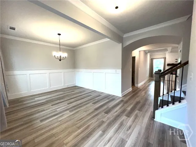 a view of a hallway with wooden floor and staircase