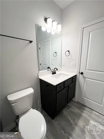 a bathroom with a sink a toilet a mirror a bathtub and shower