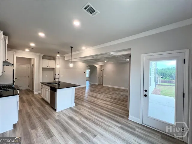 a large kitchen with stainless steel appliances a large counter top and a wooden floors