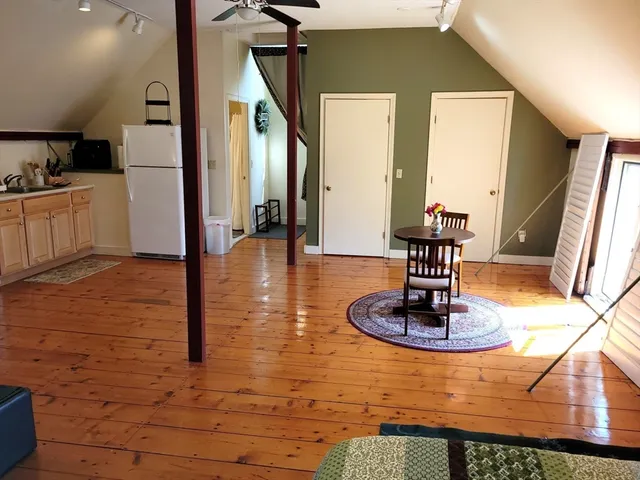 a dining hall with a stove kitchen island granite countertop a refrigerator a stove and a sink