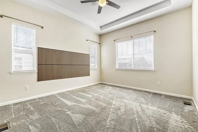a view of an empty room with a window and a chandelier fan