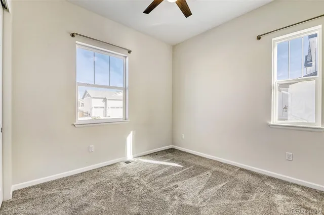 an empty room with a window and a ceiling fan