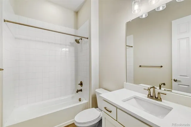 a bathroom with a sink toilet vanity and shower