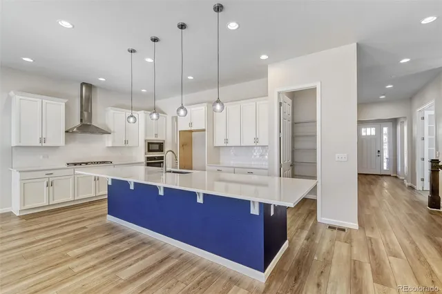 a large kitchen with stainless steel appliances kitchen island granite countertop wooden cabinets and a granite counter tops
