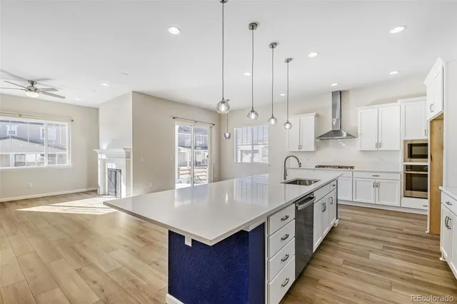 a large kitchen with stainless steel appliances kitchen island granite countertop a large center island and a wooden floor