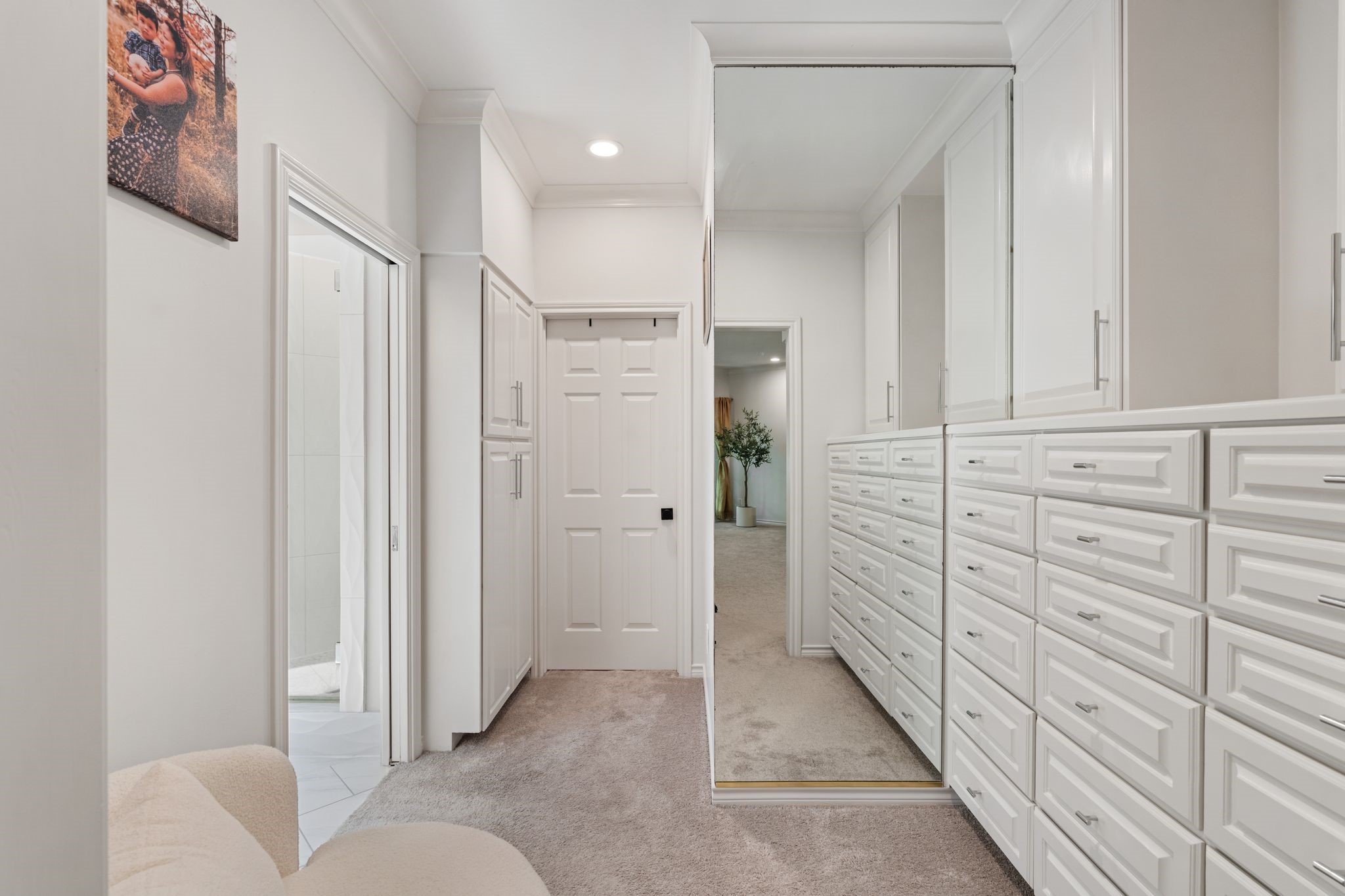201 Vanderpool Lane, Unit 137 Houston, TX 77024 - Photo 25 of 42 Before entering the spa-like bathroom and oversized walk-in closet, you’re welcomed by a huge dressing room complete with built-in dressers and incredible storage. The custom-designed closet through the door ahead features extensive built-in cabinetry that makes everyday living feel elevated and organized.