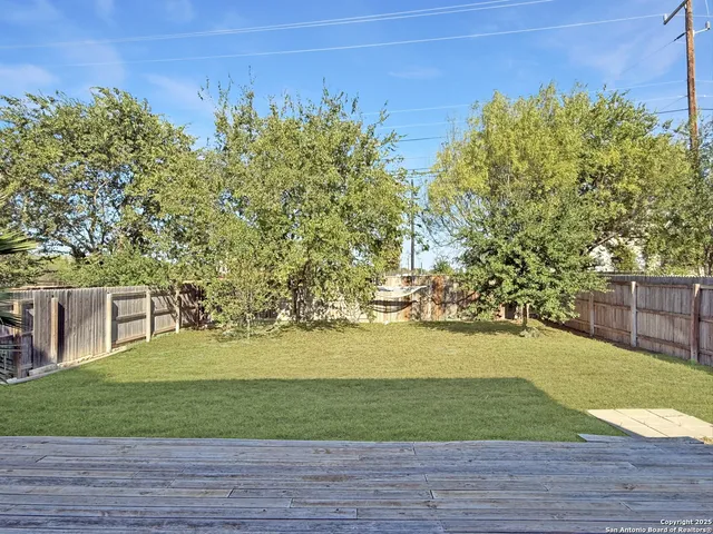 a view of a yard with wooden fence