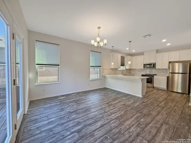 a view of kitchen with wooden floor electronic appliances and window
