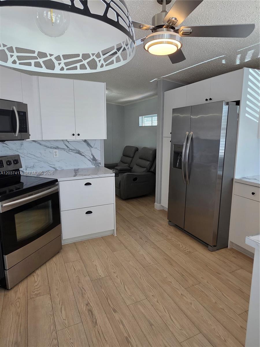 17350 Southwest 232nd Street, Unit 47 Miami, FL 33170 - Photo 5 of 9 a kitchen with stainless steel appliances granite countertop a stove and a refrigerator