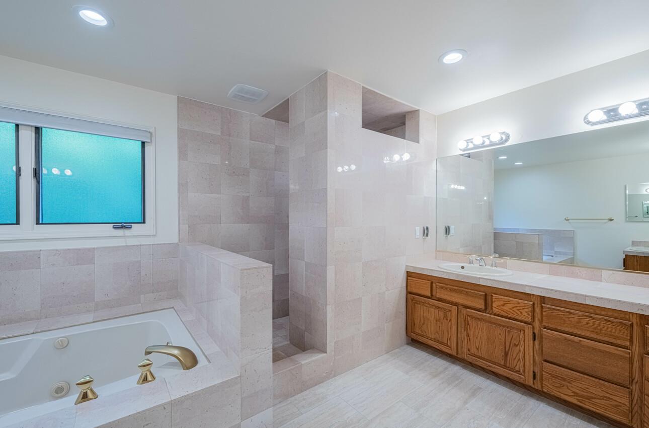 4055 Sunset Lane Pebble Beach, CA 93953 - Photo 17 of 23 a bathroom with a tub a sink double vanity and a mirror