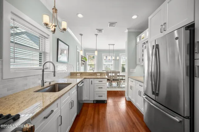 a kitchen with stainless steel appliances granite countertop a sink refrigerator and cabinets