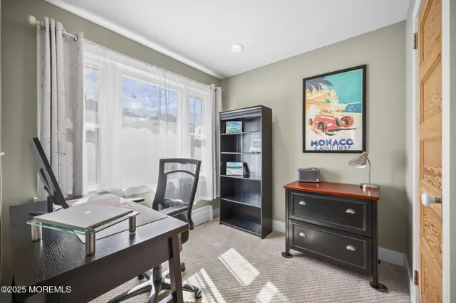 a view of a workspace with furniture and a window