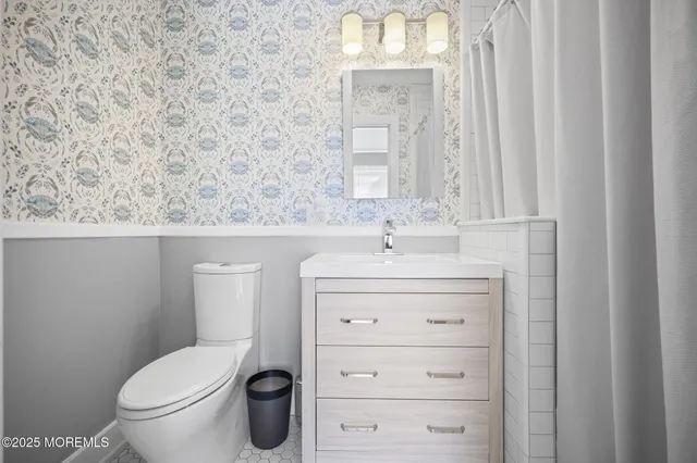 a bathroom with a sink a toilet and a mirror