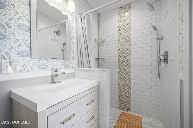 a bathroom with a sink a vanity and shower