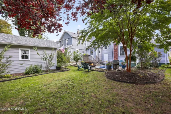 a view of a house with backyard and a tree