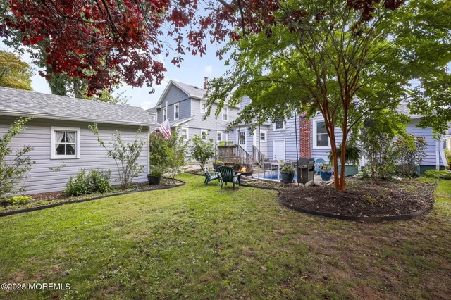 a view of a house with backyard and a tree