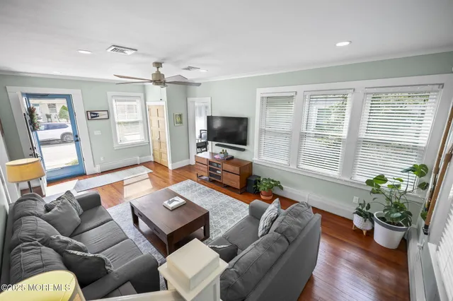 a living room with furniture potted plant and a flat screen tv