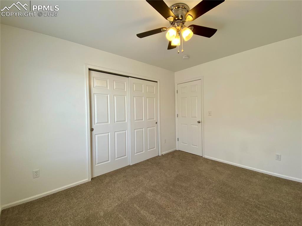 7513 Sandy Springs Point Fountain, CO 80817 - Photo 28 of 38 an empty room with a chandelier fan and a ceiling fan