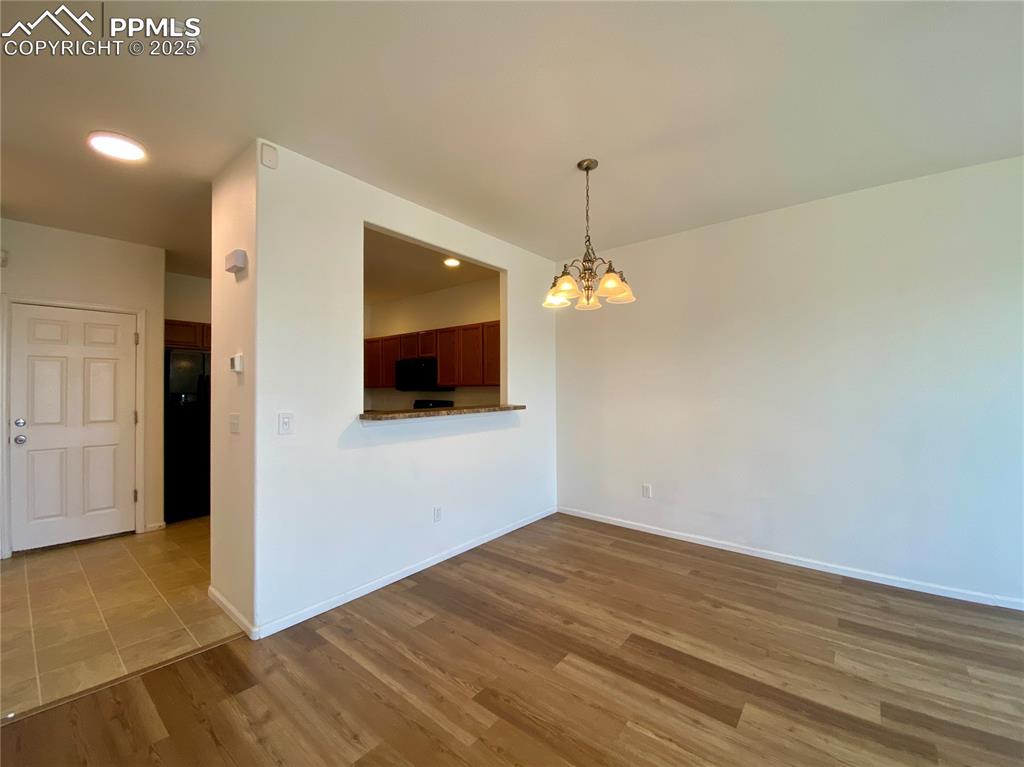 7513 Sandy Springs Point Fountain, CO 80817 - Photo 3 of 38 a view of empty room with wooden floor and kitchen