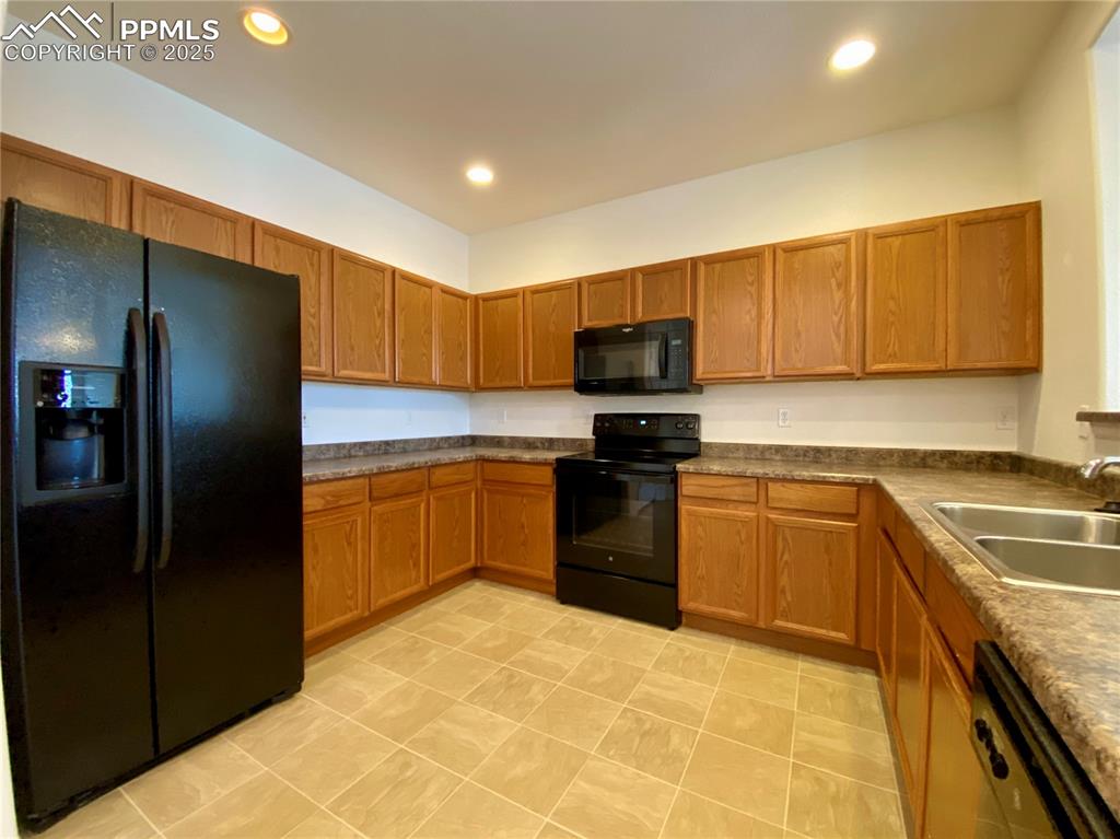 7513 Sandy Springs Point Fountain, CO 80817 - Photo 9 of 38 a kitchen with a sink a stove and refrigerator