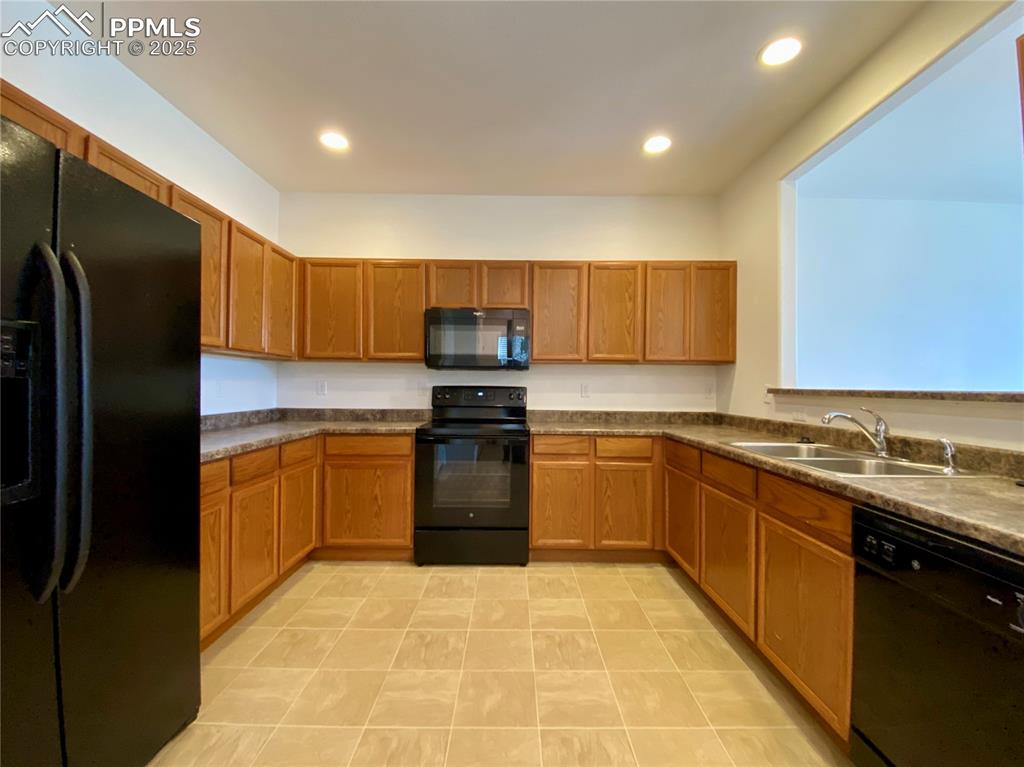 7513 Sandy Springs Point Fountain, CO 80817 - Photo 10 of 38 a kitchen with stainless steel appliances granite countertop a refrigerator and a stove top oven